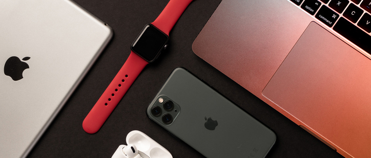 Flat Lay of different apple products on a dark grey background.